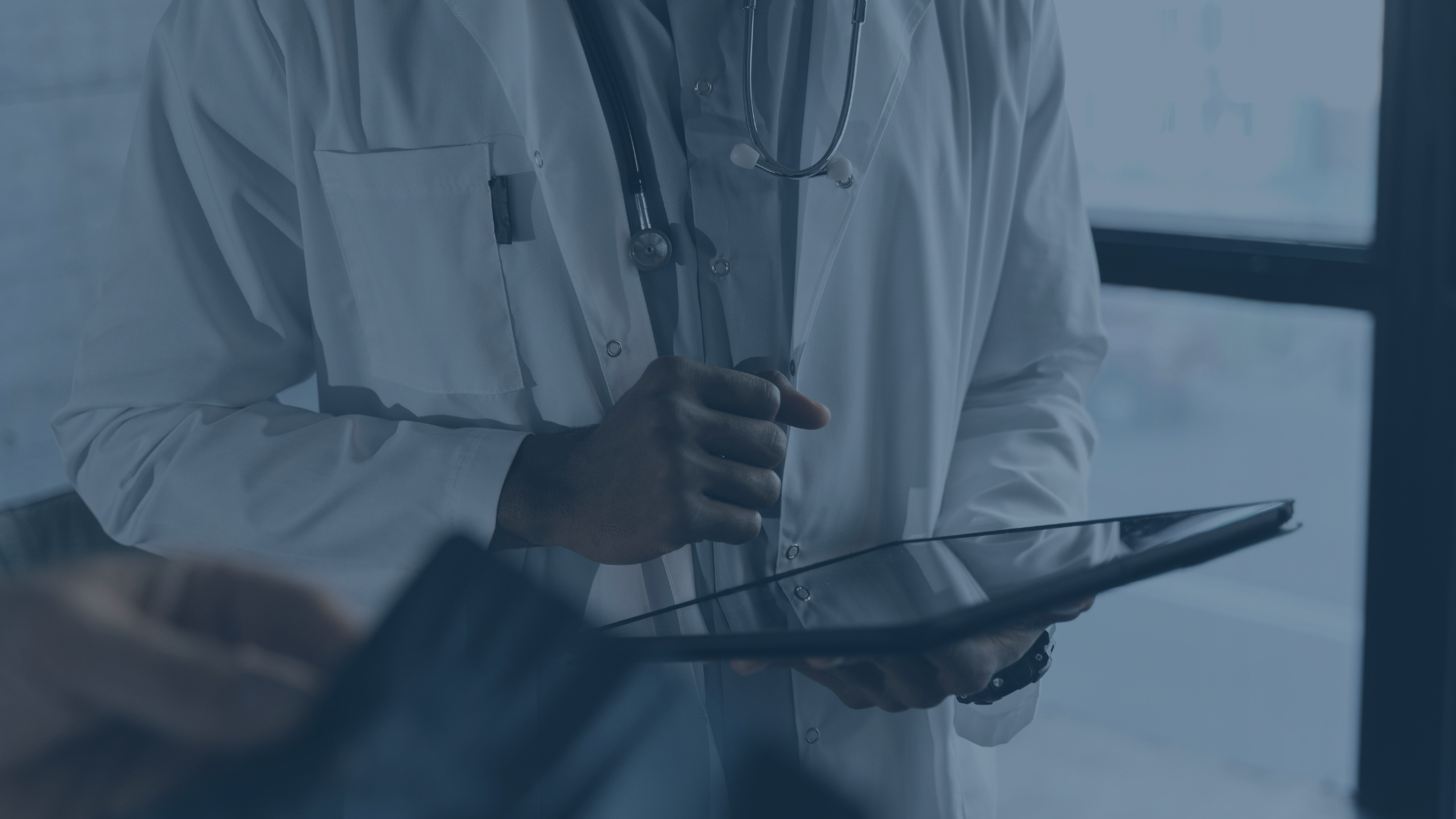 Ein Arzt im weißen Kittel hält ein Tablet in der Hand – Symbolbild für den digitalen Wandel im Gesundheitswesen. Die Elisabeth-Klinik Bigge setzt im Rahmen eines Mobile Device Management-Projekts gemeinsam mit audius auf moderne Technologien wie Jamf Pro und den Apple Business Manager zur zentralen Verwaltung mobiler Endgeräte.