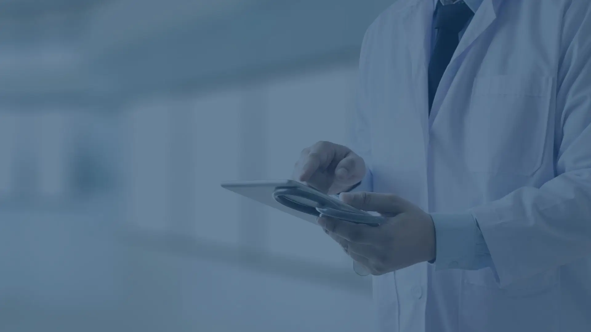 Download Geld oder Leben Arzt in weißem Kittel bedient Tablet in modernem Krankenhausflur zur digitalen Patientenakte.