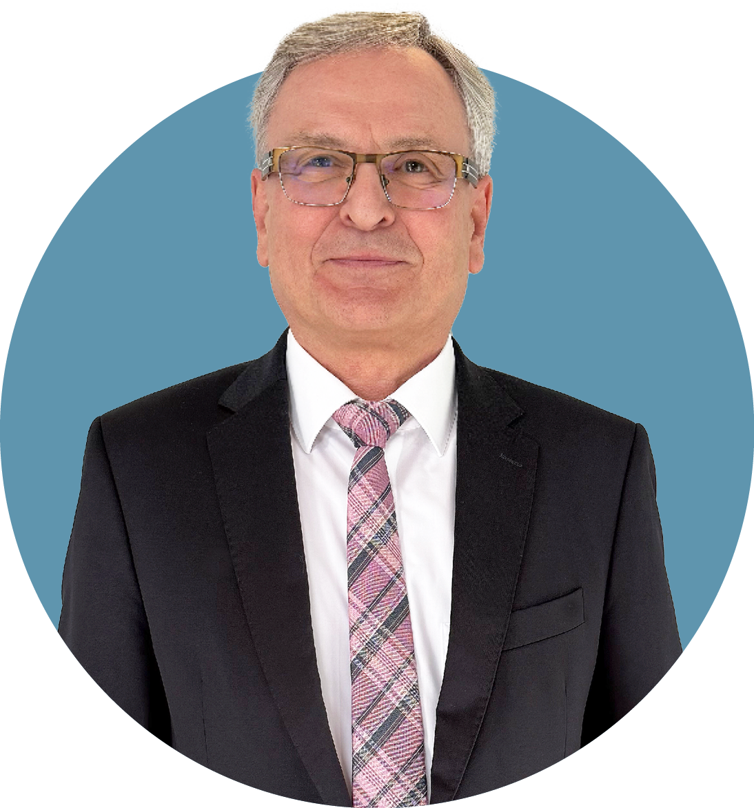 Porträt von Jürgen Tschiesche, Aufsichtsrat der audius SE, lächelnd in dunklem Sakko und weißem Hemd vor blauem Hintergrund.