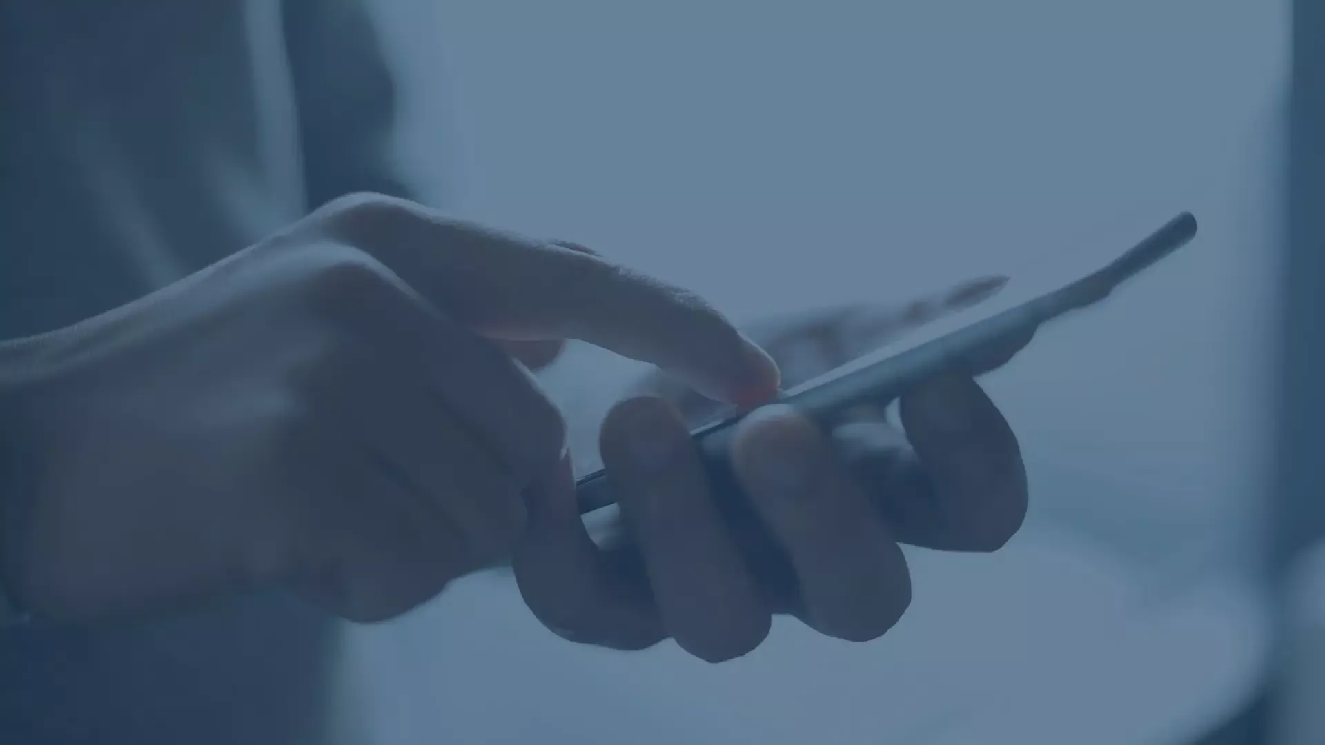 Nahaufnahme einer Hand, die auf einem Smartphone tippt, als Symbol für Mobile Device Management (MDM).