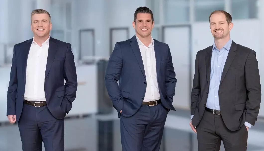 Gruppenaufnahme der audius Geschäftsführung – Die Vorstände der audius SE präsentieren sich als geschlossenes Management-Team in einem modernen Arbeitsumfeld.